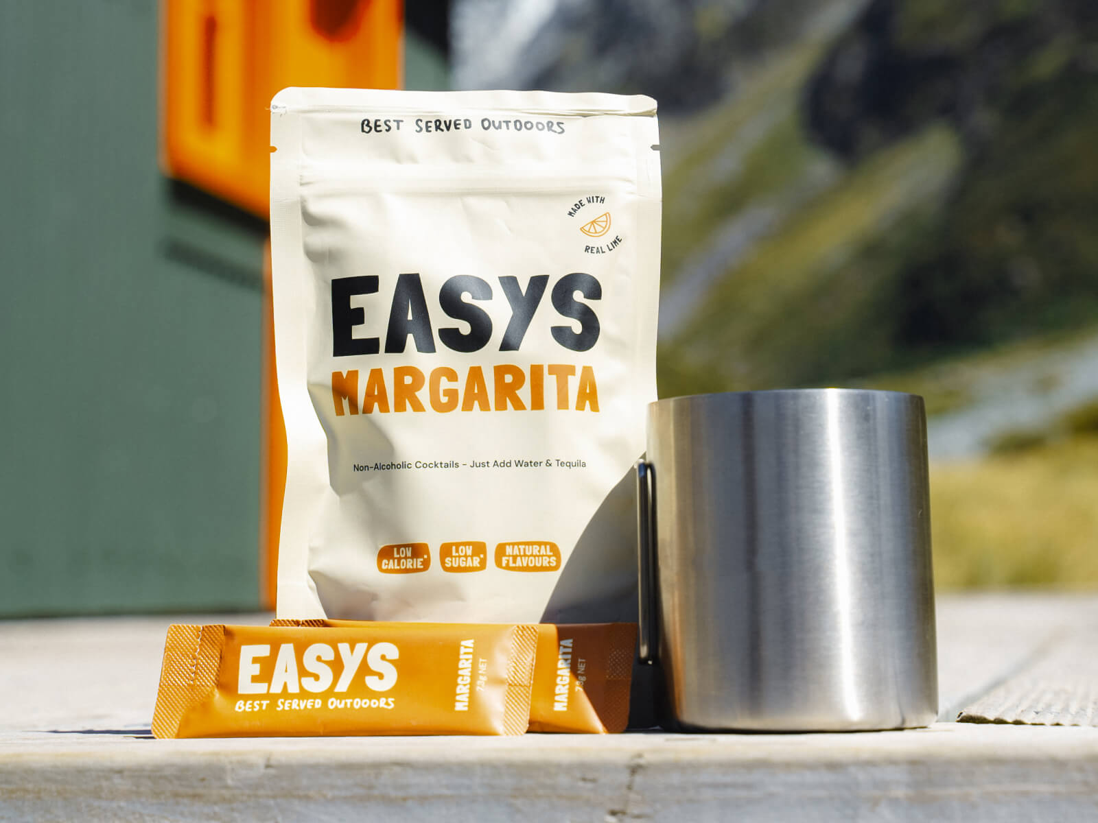 A refreshing Margarita made with Easys cocktail mix, placed outside a cozy backcountry hut, perfect for unwinding after a hike.