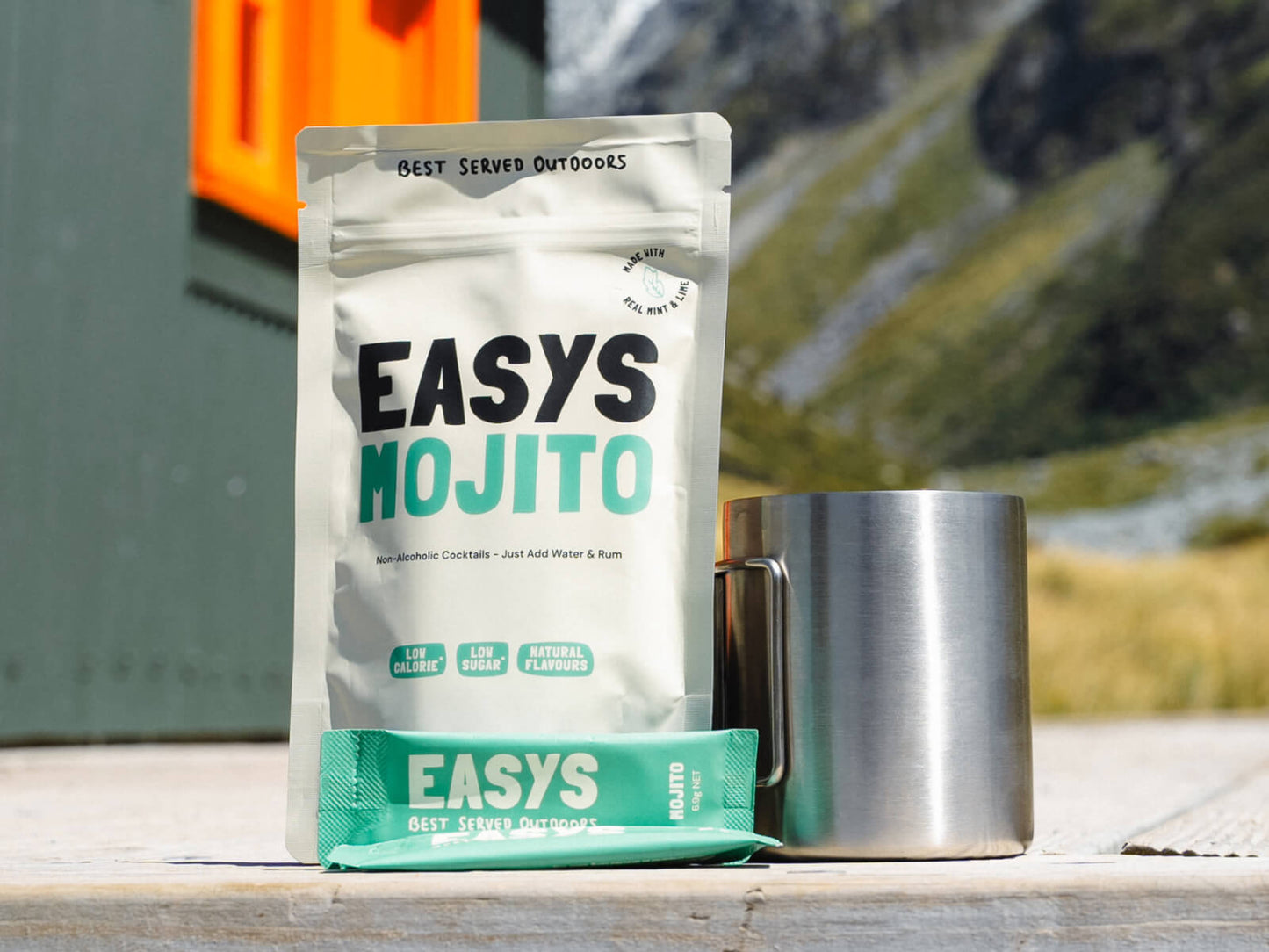 A refreshing Mojito made with Easys cocktail mix, placed outside a cozy backcountry hut, perfect for unwinding after a hike.