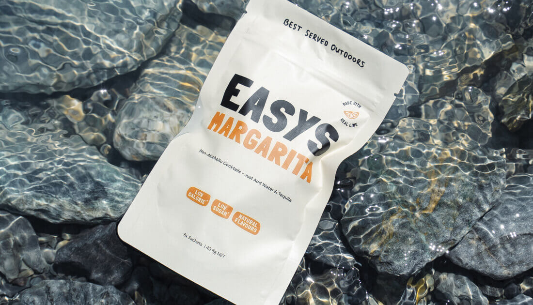 An Easys cocktail packet floating in crystal-clear water, symbolizing its clean, natural ingredients and refreshing taste.