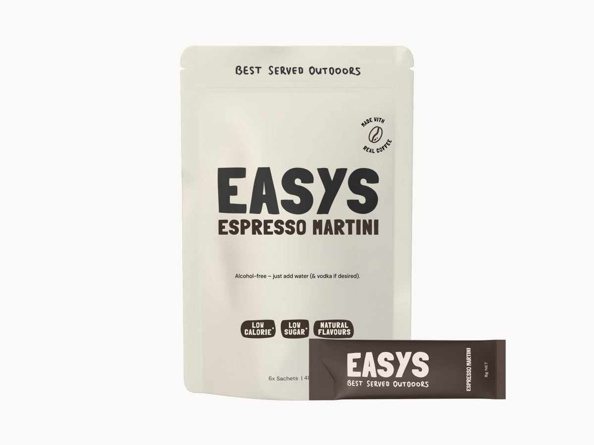 Easys Espresso Martini 6-pack of powdered cocktail mix sachets, with a single sachet in front. Studio photo on a white background.