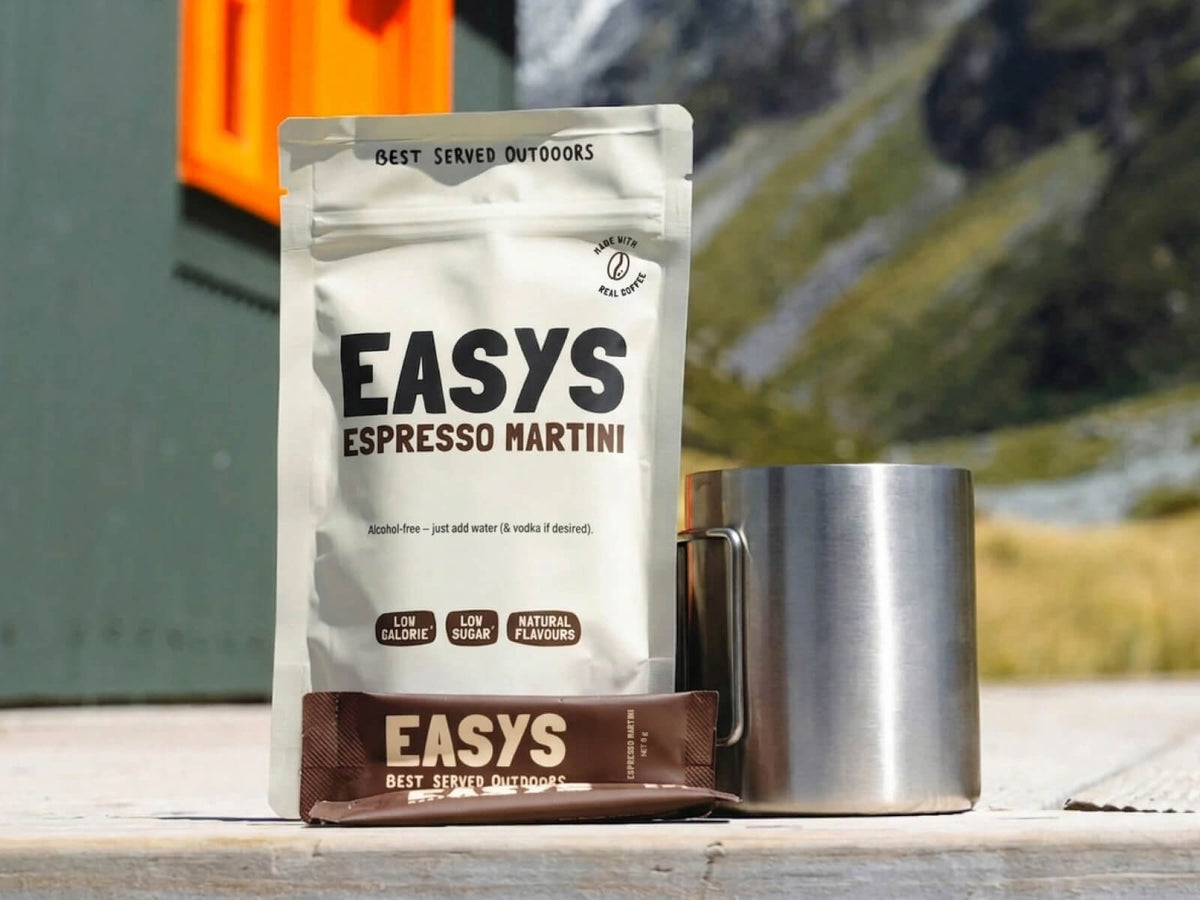 A refreshing Espresso Martini made with Easys cocktail mix, placed outside a cozy backcountry hut, perfect for unwinding after a hike.