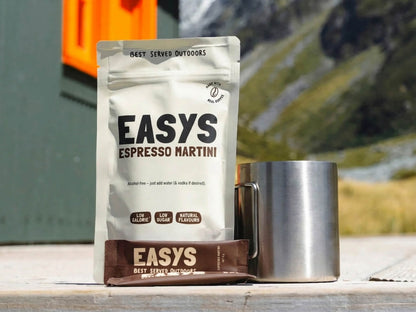 A refreshing Espresso Martini made with Easys cocktail mix, placed outside a cozy backcountry hut, perfect for unwinding after a hike.